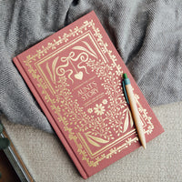 Decorative red book 'Aunt's Story' with gold embossed design on a textured surface
