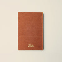 Brown notebook with a brand logo on a beige background
