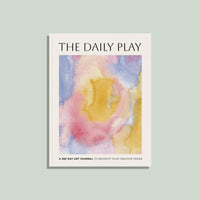 Book titled 'The Daily Play' with a watercolor cover on a light green background