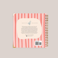Back cover of a spiral-bound notebook with pink and white striped design and text.