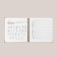 Open view of 'Modern Calligraphy' with calligraphy practice pages on a beige background