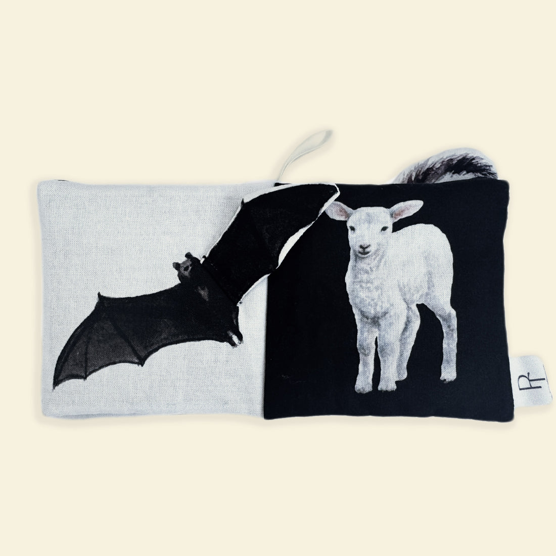 Book with a bat on one side and a lamb on the other, on a beige background.