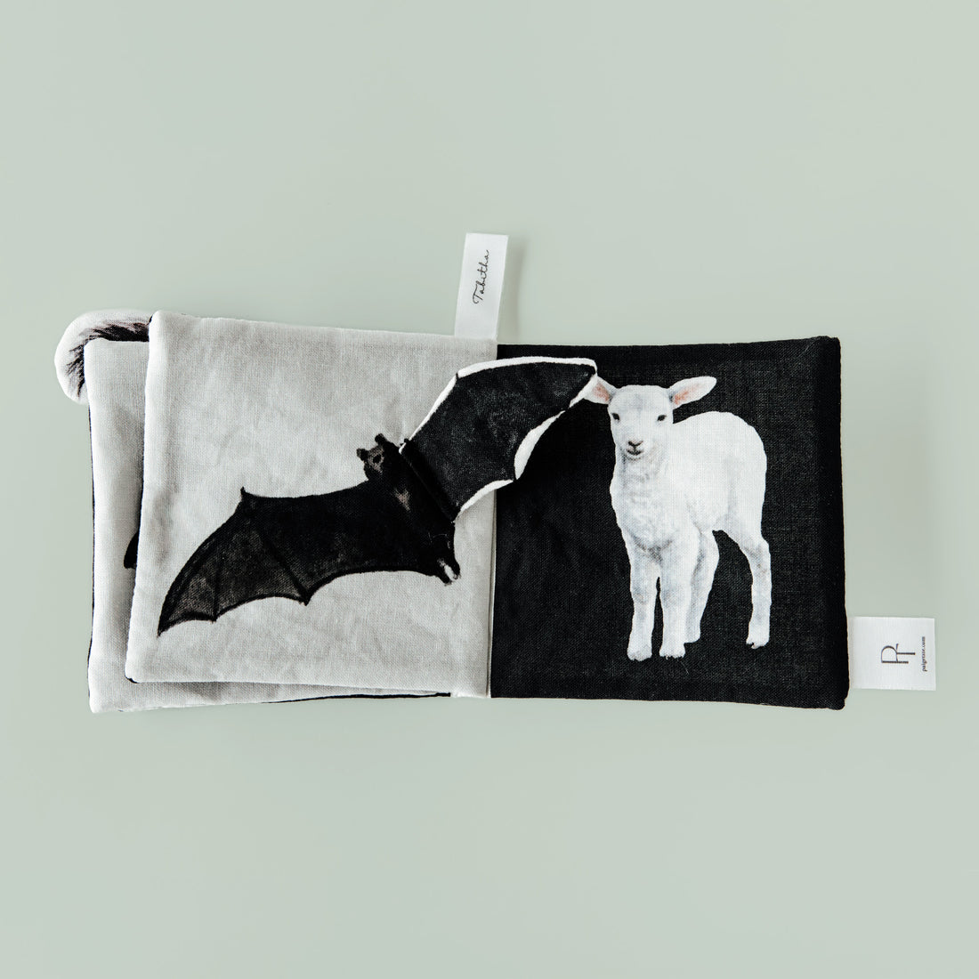 Two fabric pouches with bat and lamb designs on a light gray background