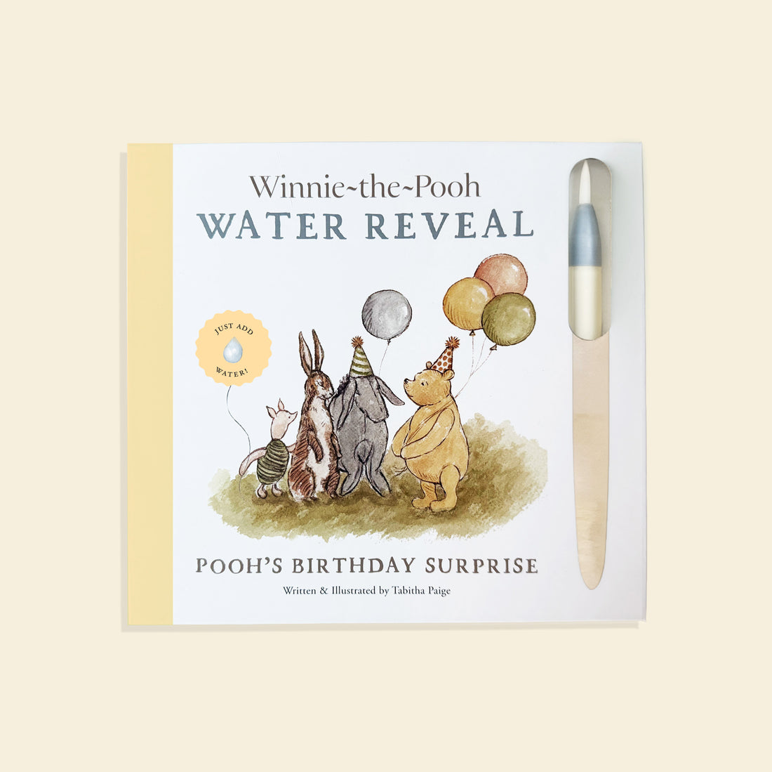 Winnie-the-Pooh themed water reveal book with a pen on a beige background