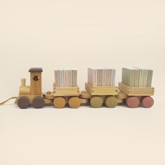 Wooden toy train with three cargo boxes on a beige background