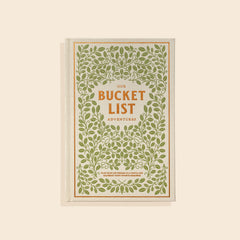 Book cover of "Our Bucket List Adventures" has a beige cloth cover with green leafy designs and a gold lettering. 