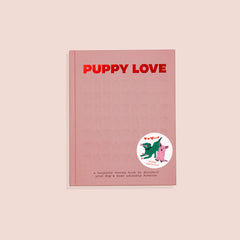 A pink-colored keepsake memory book with the title 'PUPPY LOVE' written in bold letters on the cover. There is an illustration of a happy dog and a cat sharing a bone on the bottom right of the cover.